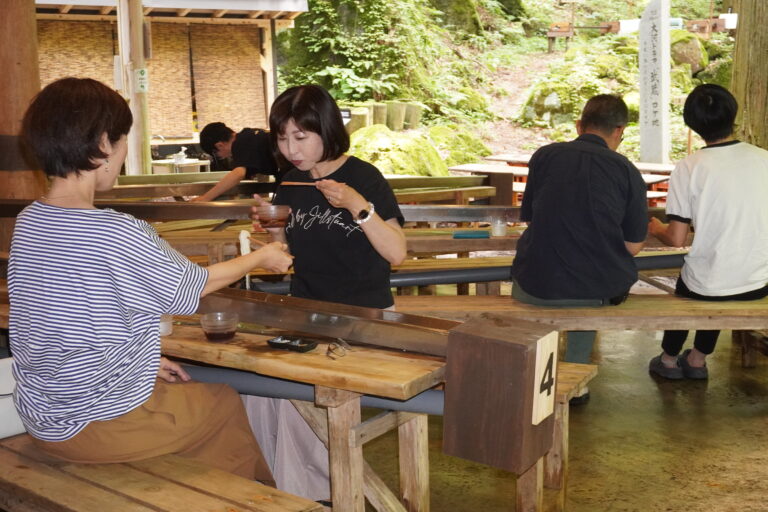 涼水亭の流しそうめんを味わう来店客=岡山県真庭市で