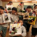 完成した作品をかかげる3年生