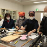 お年寄りたちに教わりながら巻きずしを作る生徒たち=岡山県津山市で