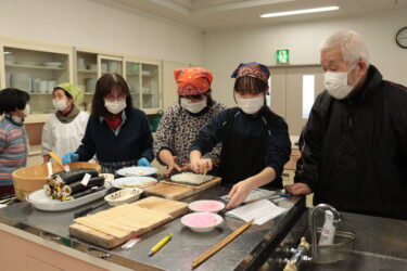 お年寄りたちに教わりながら巻きずしを作る生徒たち=岡山県津山市で