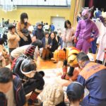 ヒーローと一緒に心肺蘇生に挑戦する参加者=岡山県津山市で