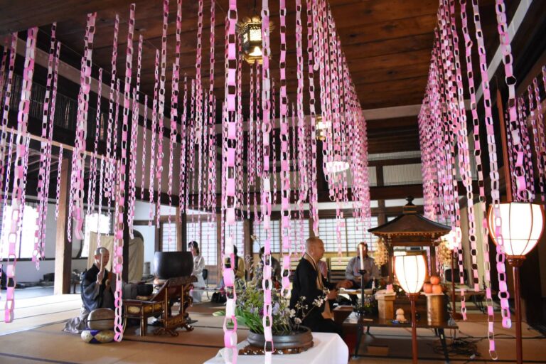 手作りの輪飾りで彩られた本源寺本堂で行われた法要=岡山県津山市で
