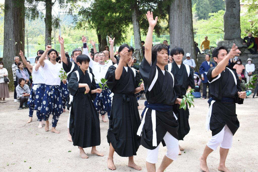 「田植」でサカキの葉をまく男衆