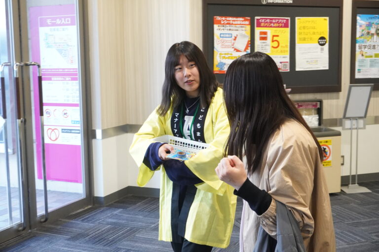 買い物客に説明しながら啓発グッズを配布する参加者=岡山県津山市で