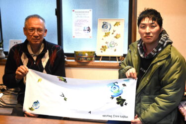 オリジナルタオルを手にする廣山さん（右）と、かじか荘の宿主・秦正明さん=岡山県真庭市で