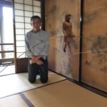 竹斎の絵を背景に展示された作品=岡山県津山市で