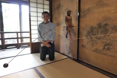 竹斎の絵を背景に展示された作品=岡山県津山市で