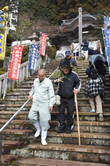 福笹を手に下山する参拝者=岡山県津山市で