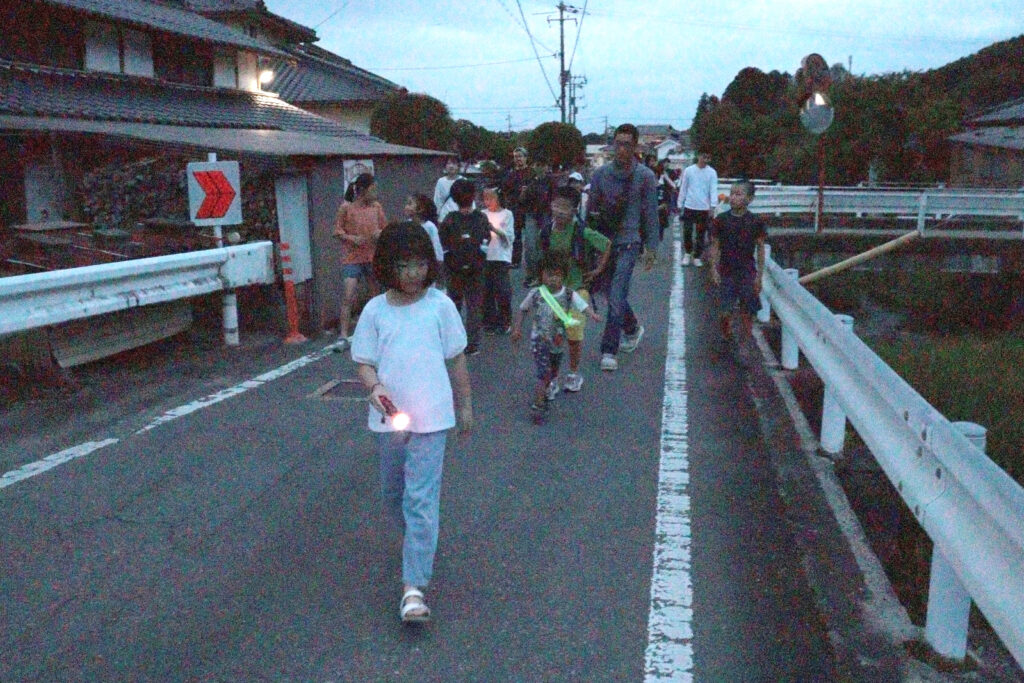 ホタルを観賞しようと目的地まで歩く参加者