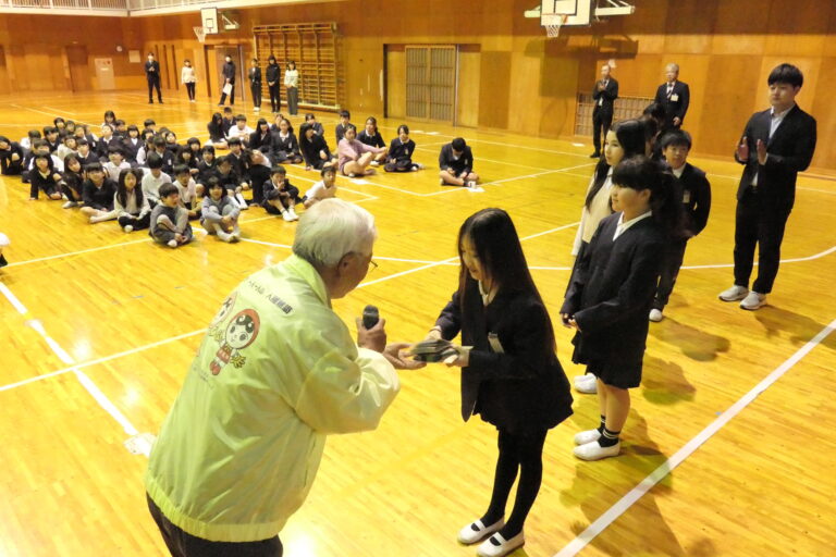 花の種を受け取る環境人権委員の児童＝岡山県津山市で
