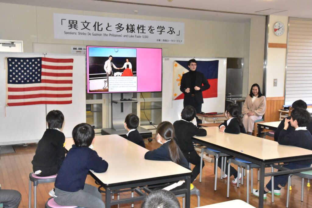 出身地の米国ミネソタ州の気候や湖などについて解説するルークさん=岡山県真庭市久世の草加部小学校で