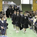 新デザインのブレザーや旧デザインのセーラー服などの制服に身を包み、入場する新入生