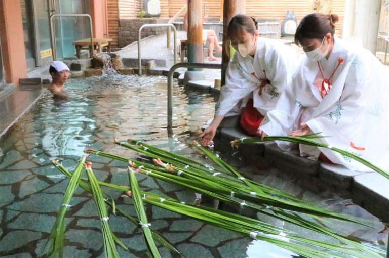 露天風呂にショウブの葉を浮かべる巫女