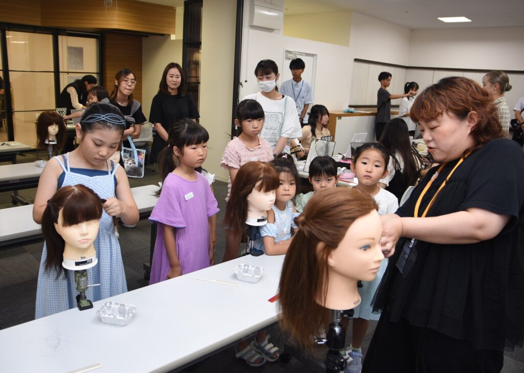 ヘアアレンジを真剣な表情で学ぶ子どもたち