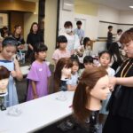 ヘアアレンジを真剣な表情で学ぶ子どもたち