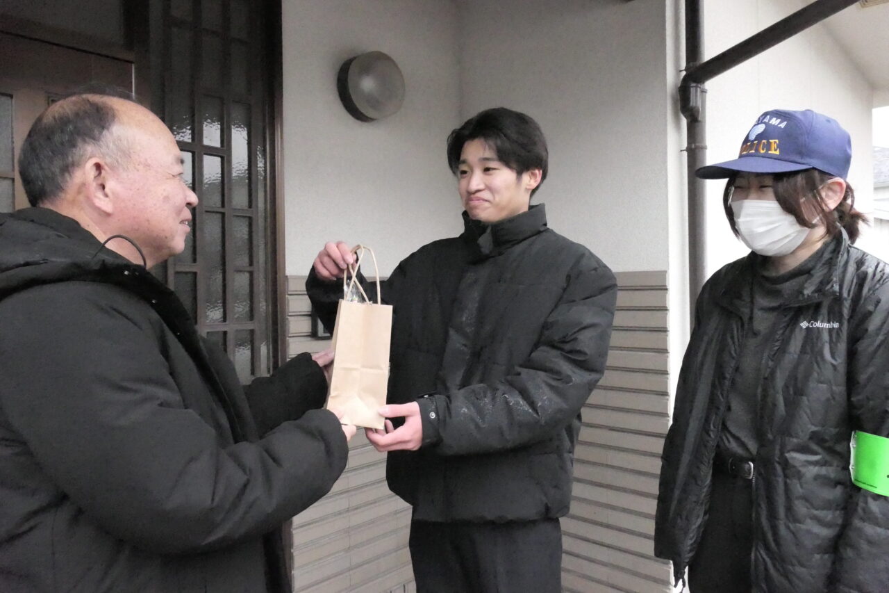 感謝の気持ちを込めてプレゼントを手渡す津山東高生=岡山県津山市東一宮で