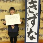 第63回「全国書道展」で大東文化大学学長賞に輝いた作品を手にした繁定さん