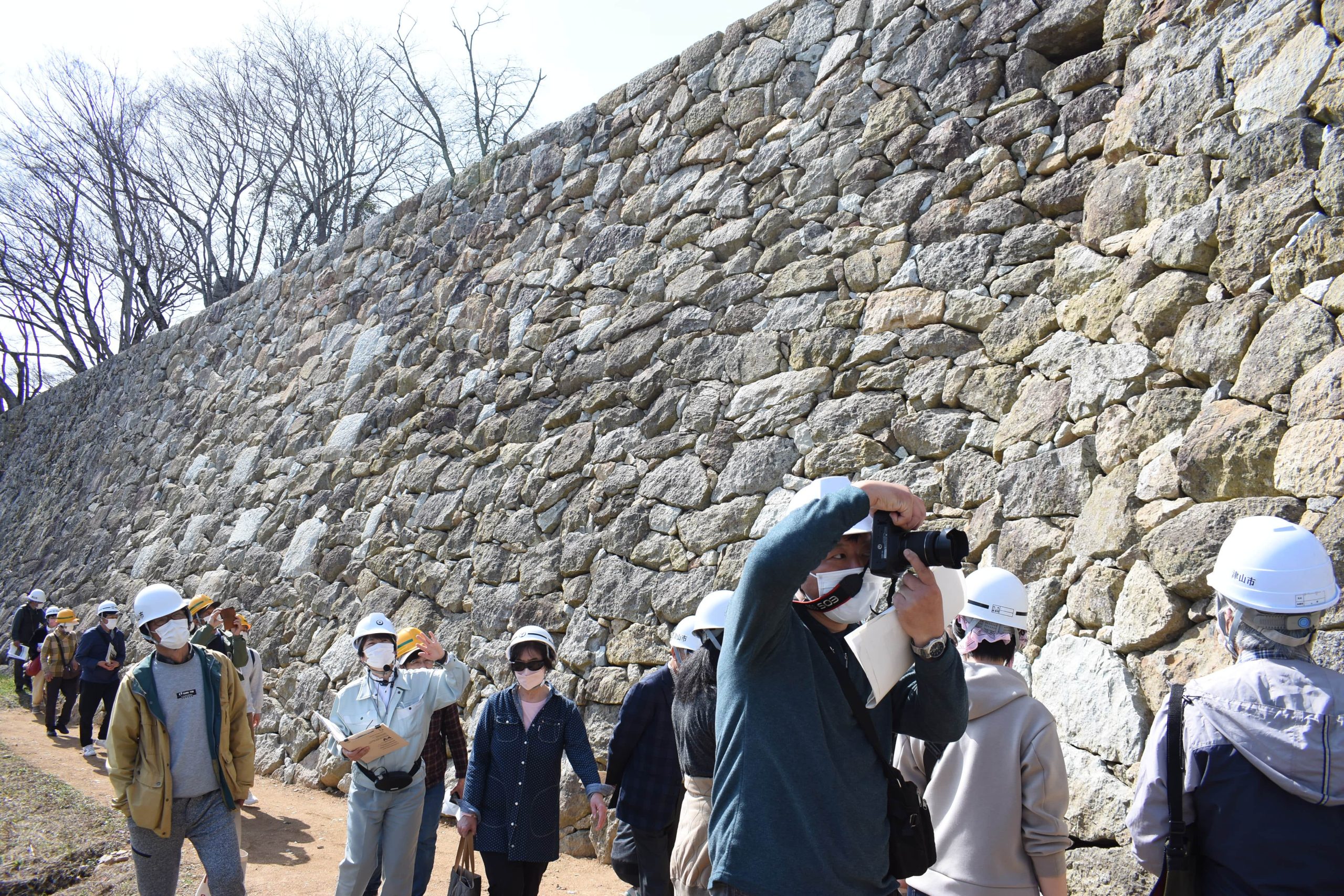 修理工事が終わった石垣を見学する参加者たち