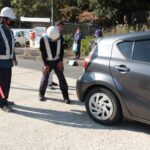 国道53号を走行する車のタイヤを確認する職員