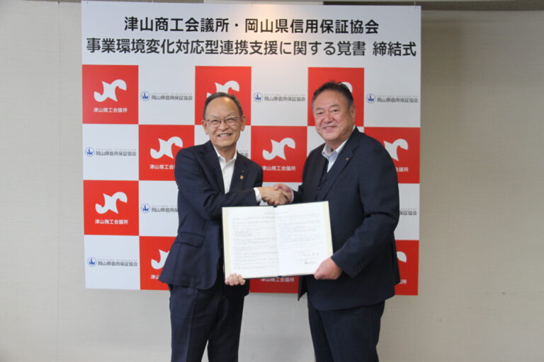 覚書を交わし、握手する松田欣也会頭（右）と横田有次会長＝岡山県津山市で