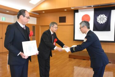 西村消防長から表彰を受ける三宅さん（右）と米井さん=岡山県津山市で