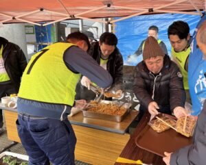 津山ホルモンうどんの炊き出しを行う会員ら=2024年3月3日、石川県輪島市で