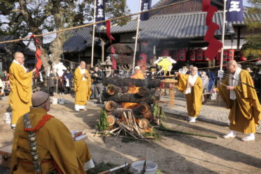 護摩壇に護摩木を投げ入れる僧侶たち=岡山県津山市で