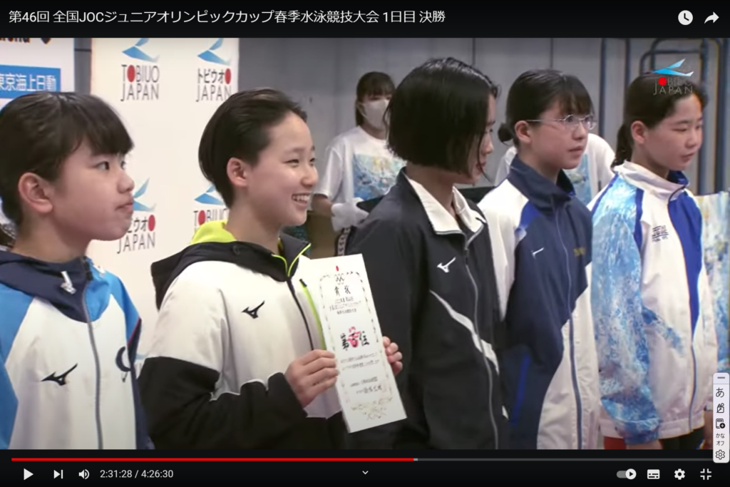 賞状を受け取り笑顔を見せる芦田選手（日本水泳連盟公式ユーチューブチャンネル）