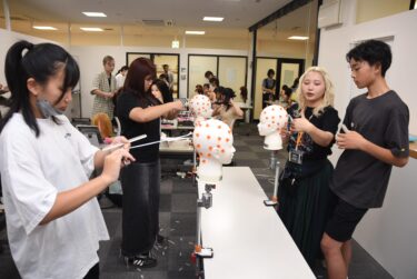 練習用ウィッグを使ってカットに挑戦する中高生=岡山県津山市で
