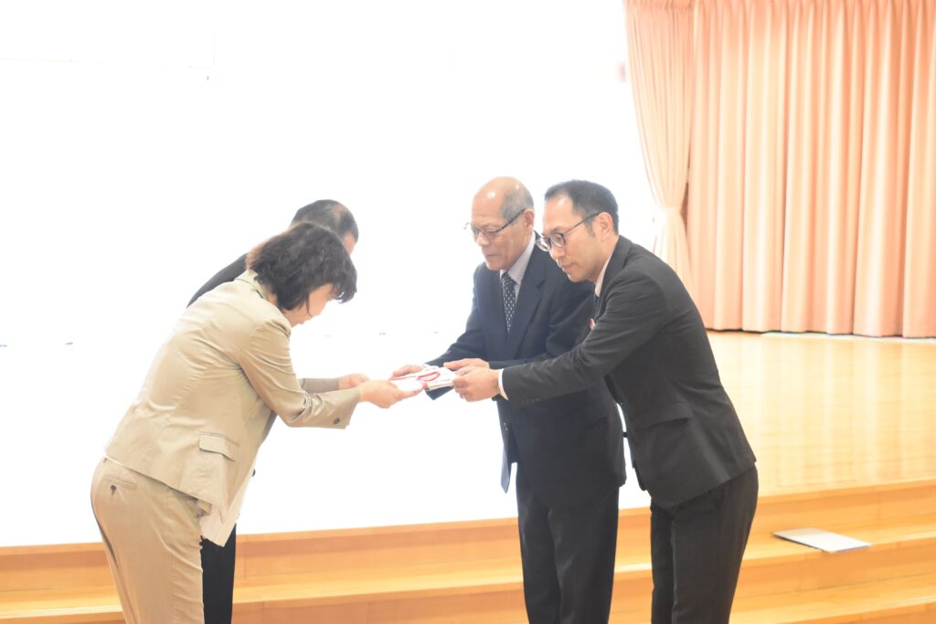 目録を手渡す有本代表取締役(右から2番目)ら