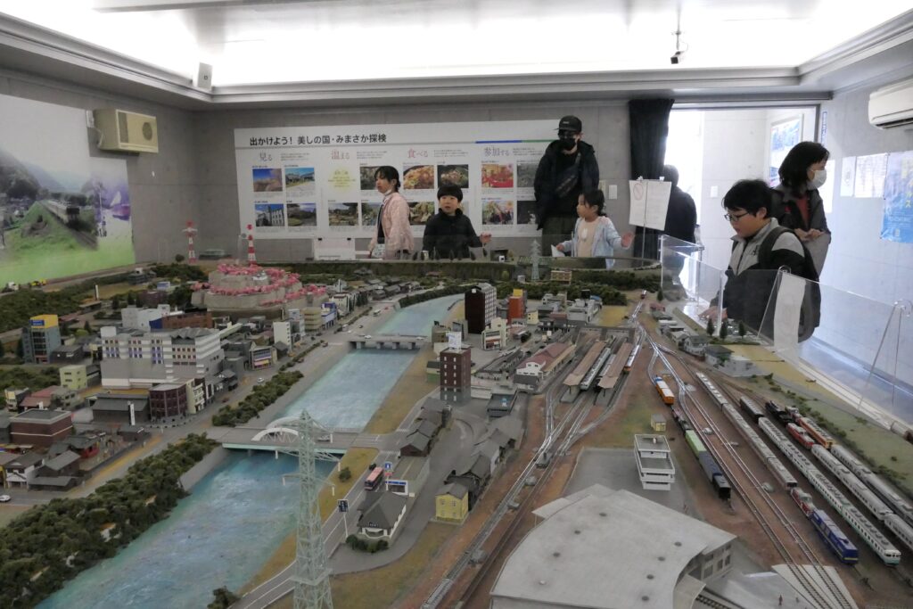 津山市の町並みを模したジオラマと鉄道模型を観賞する参加者