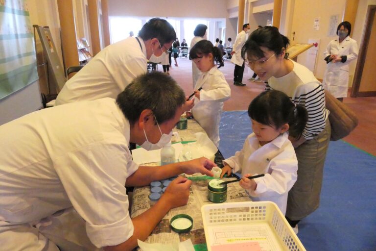 白衣を着て薬剤師体験をする子供たち=岡山県津山市で