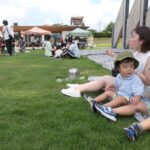芝生で食事を楽しむ親子ら=グリーナブルヒルゼンで