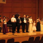 賞状とトロフィーを受け取る入賞者