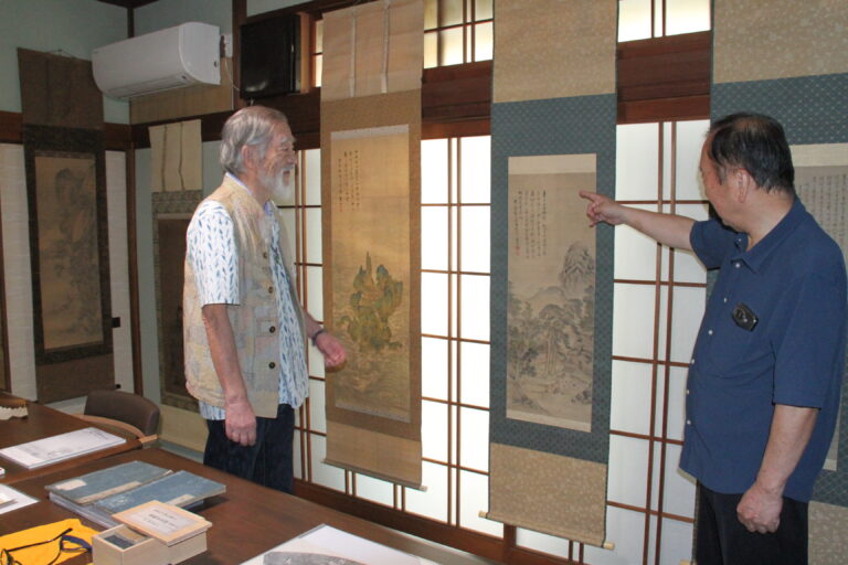 竹内さんから解説を受けながら作品を鑑賞する来場者＝岡山県津山市で
