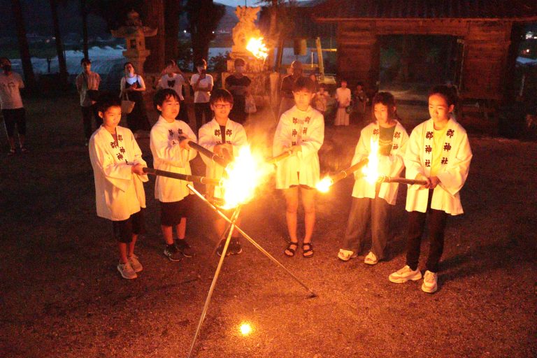 神火をたいまつへ移す年男・年女の小学生たち＝岡山県真庭市＝