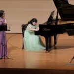 フルートに合わせて優しい音色を紡ぐ川嶋さん（中央）=岡山県津山市で