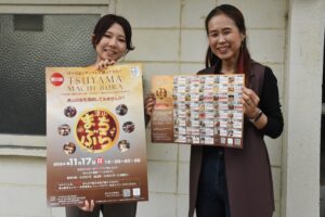 「津山まちぶら」のポスターとマップを手にする実行委メンバー=岡山県津山市で