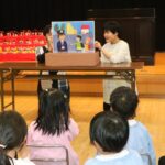 紙芝居「こんなむらいやだ～」に見入る園児たち=岡山県津山市で