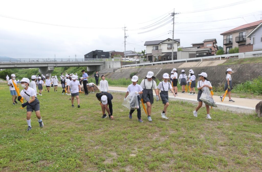 河川敷を清掃する児童と高校生たち