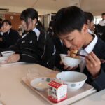 津山産小麦を活用した揚げパンを食べる生徒=岡山県津山市で