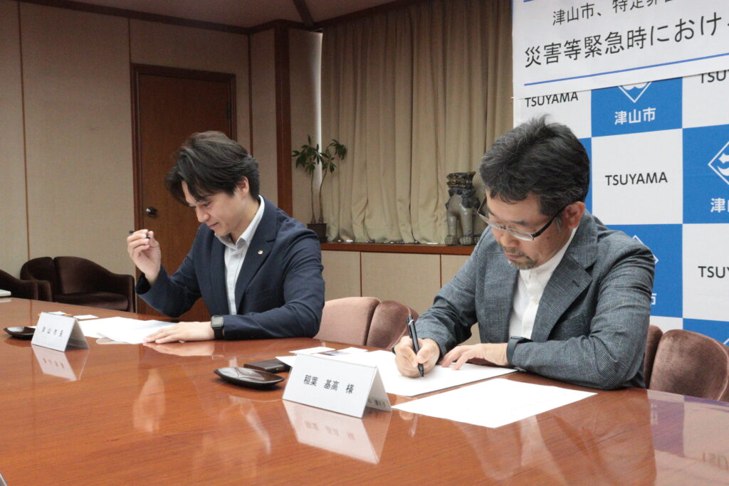 協定書に署名する稲葉医師(右)と光井市長