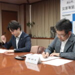 協定書に署名する稲葉医師（右）と光井市長
