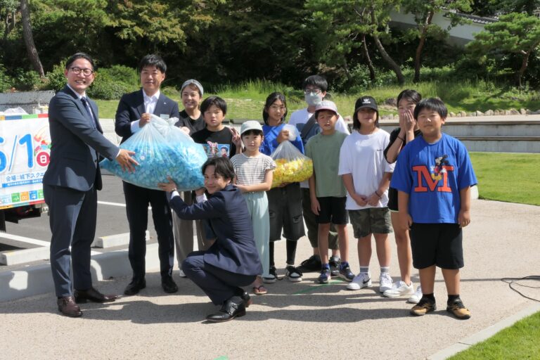 キャップを岩元社長に手渡す津山JCメンバー=岡山県津山市で