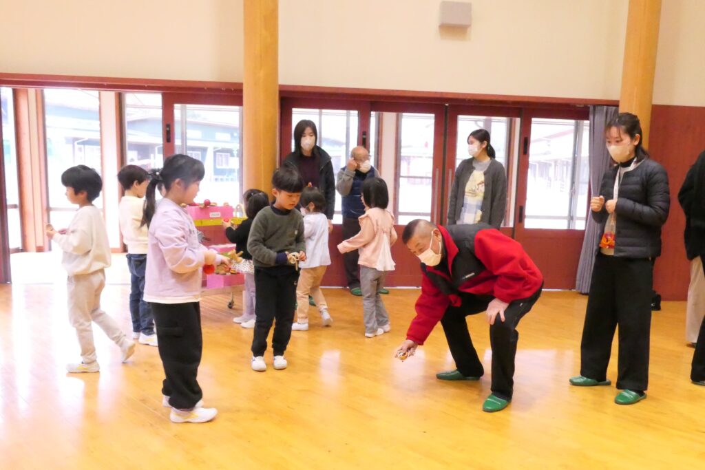 上手にこまを回す方法を教わる園児たち