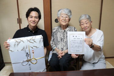 次女の河原さん（右）と光井市長（左）から祝福を受ける倉田さん＝岡山県津山市で