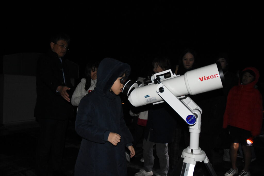 対空双眼鏡で星を観察する子どもたち