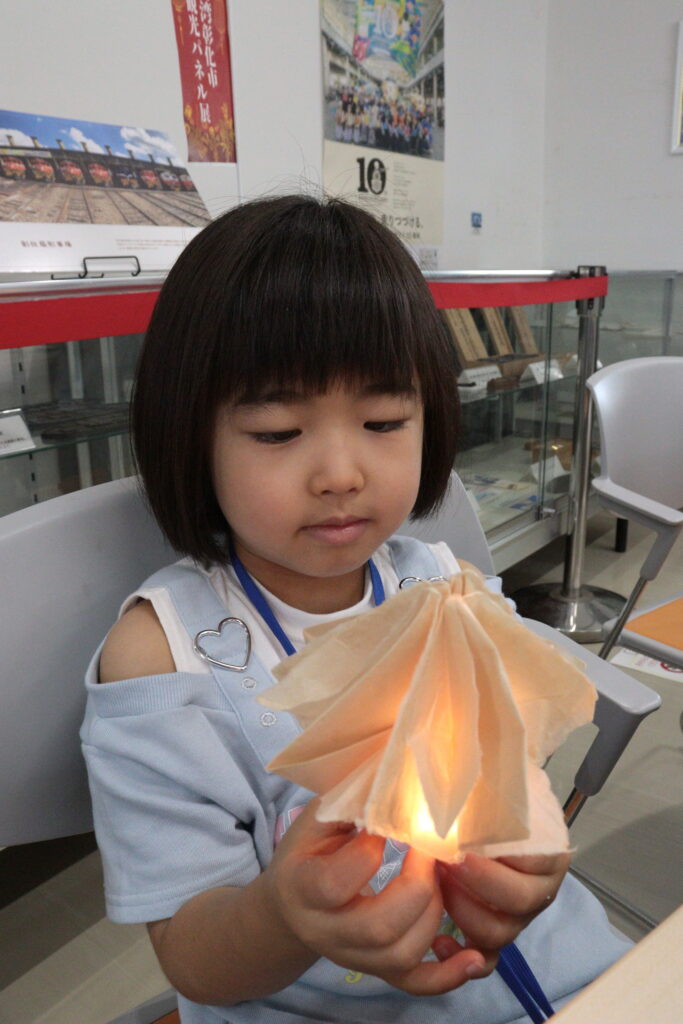 完成したランプシェードをうれしそうに眺める子ども