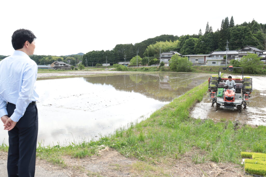 田植えの様子を見守る伊原木知事＝本山精耕園の水田で