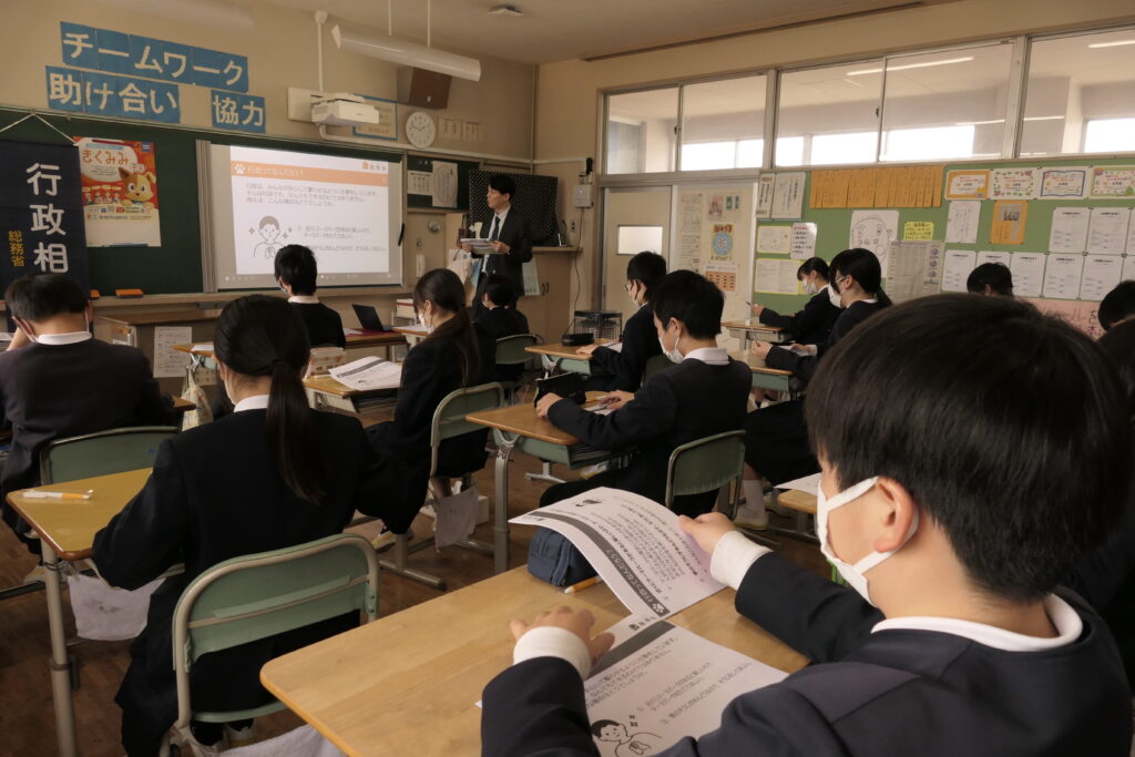 行政の仕事についての説明に耳を傾ける児童